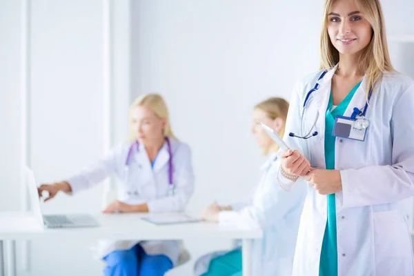 Retrato de una joven doctora, con almohadillas en la mano, en un consultorio médico —  Fotos de Stock