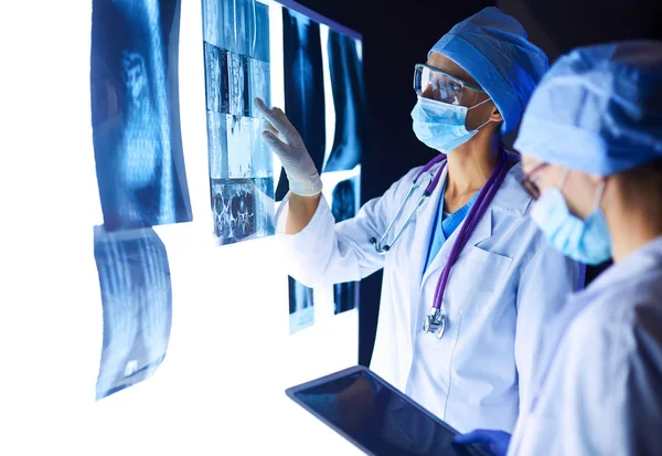 Two female women medical doctors looking at x-rays in a hospital.