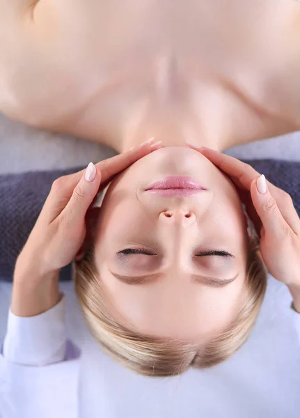 Mujer joven acostada en una mesa de masaje, relajándose con los ojos cerrados. Una mujer. Salón de spa — Foto de Stock