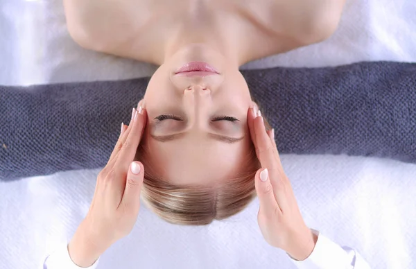 Mujer joven acostada en una mesa de masaje, relajándose con los ojos cerrados. Una mujer. Salón de spa —  Fotos de Stock