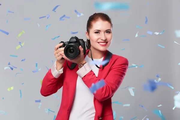 Schöne, glückliche Frau mit Kamera bei einer Feier mit Konfetti. Geburtstag oder Silvester feiern Konzept — Stockfoto