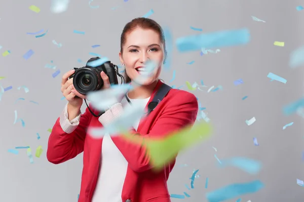 Beautiful happy woman with camera at celebration party with confetti . Birthday or New Year eve celebrating concept — Stock Photo, Image