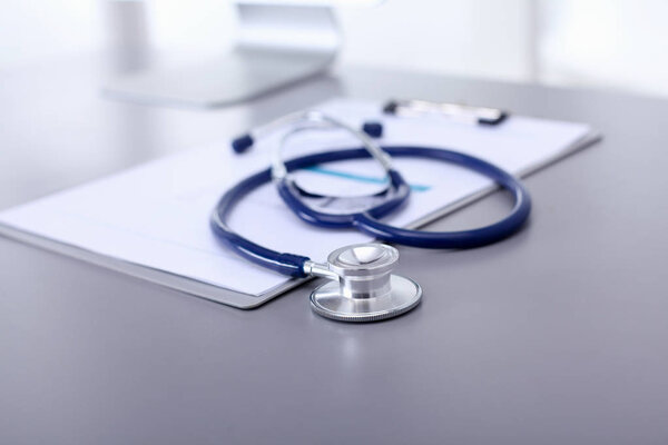 Медицинское оборудование: синий стетоскоп и таблетка на белом фоне. Медицинское оборудование