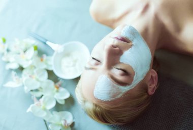 Yüz maskesi. Güzel genç kız Spa, makyajcısı kadın yüz maskesi uygulama.