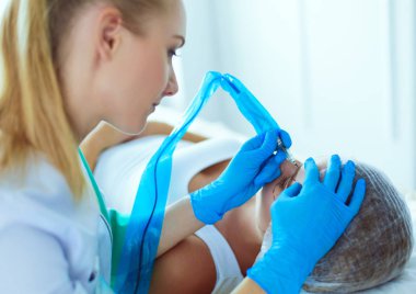 Kaşlar için kalıcı makyaj. Güzellik salonunda kalın kaşlı güzel bir kadın..