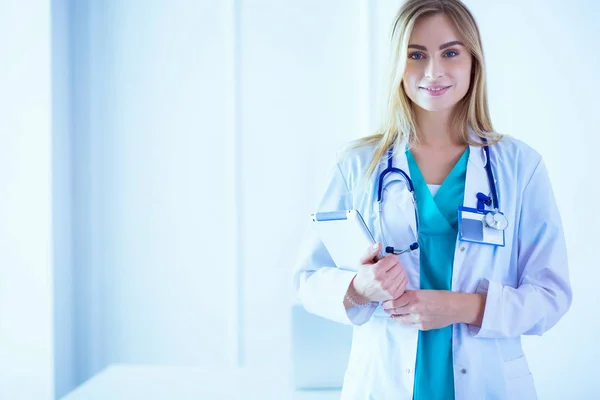 Retrato de uma jovem médica, com aipads na mão, em um consultório médico — Fotografia de Stock