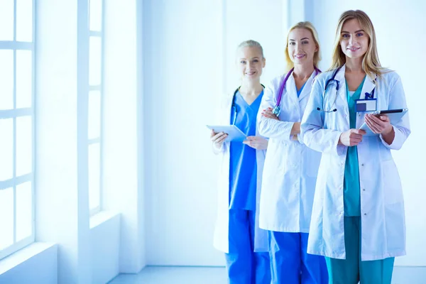 Retrato de tres doctores confiados de pie con los brazos cruzados en el consultorio médico . — Foto de Stock