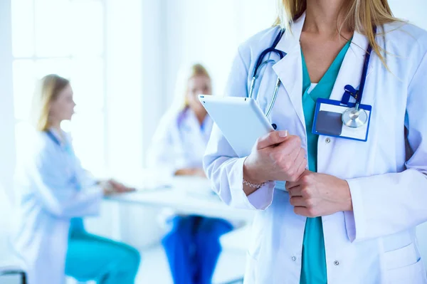 Retrato de una joven doctora, con almohadillas en la mano, en un consultorio médico — Foto de Stock