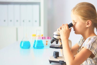 kız öğrenci fen bilgisi dersinde mikroskop aramak.