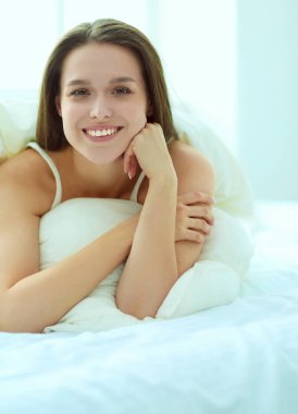 Güzel bir kadın yatağında uzanıyor..