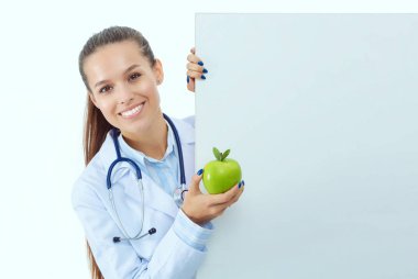 Elmalı ve boş pankartıyla gülümseyen doktor. Kadın doktorlar.