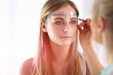 Kaşlar için kalıcı makyaj. Güzellik salonunda kalın kaşlı güzel bir kadın..