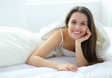 Güzel bir kadın yatağında uzanıyor..