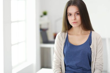 Genç kadın kendini evde aynada yansıma arıyor.