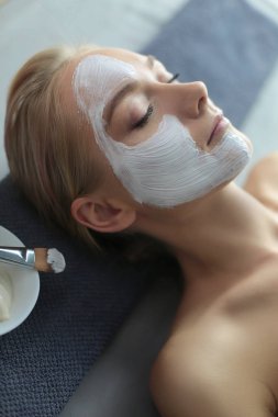 Yüz maskesi. Güzel genç kız Spa, makyajcısı kadın yüz maskesi uygulama.