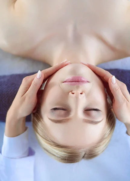 Jeune femme allongée sur une table de massage, relaxante les yeux fermés. Femme. Salon de spa — Photo