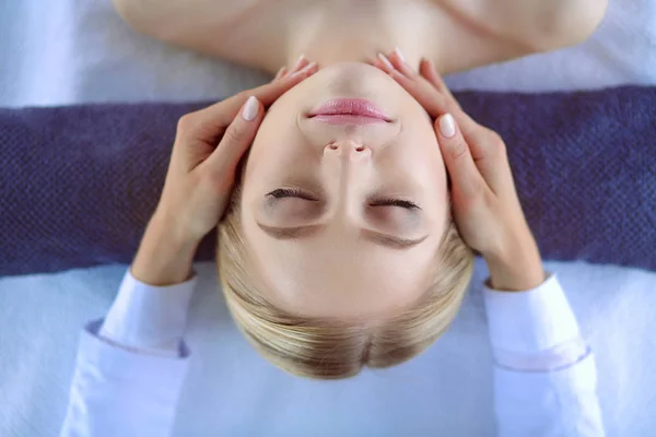 Jeune femme allongée sur une table de massage, relaxante les yeux fermés. Femme. Salon de spa — Photo