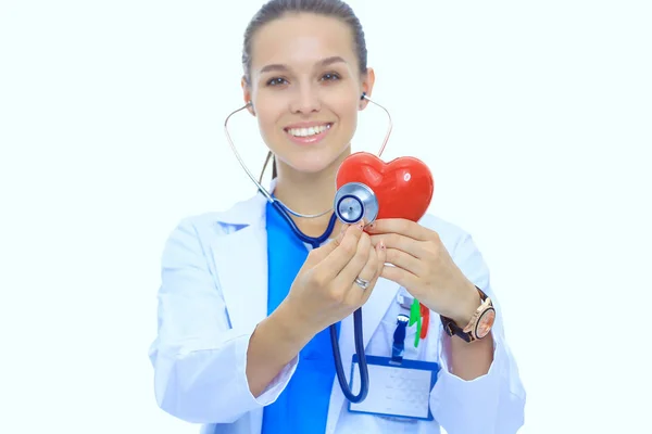 Medico femminile positivo in piedi con stetoscopio e simbolo del cuore rosso isolato. Donna medico — Foto Stock