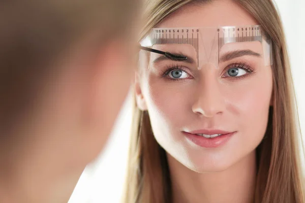 Permanent makeup for eyebrows. Closeup of beautiful woman with thick brows in beauty salon. — Stock Photo, Image