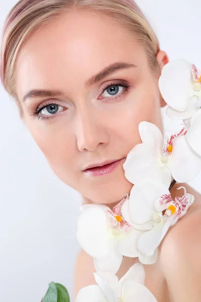 Schoonheid van de jonge vrouw met de bloem in de buurt van gezicht. — Stockfoto