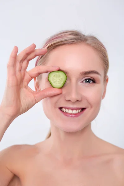 Joven hermosa mujer con rodajas de pepino sobre fondo blanco . — Foto de Stock