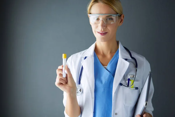 Vrouwelijke medische of onderzoekswetenschapper of arts die gebruik maakt van een reageerbuis met heldere oplossing in een laboratorium of laboratorium. — Stockfoto