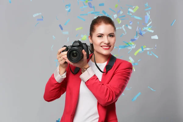 Schöne, glückliche Frau mit Kamera bei einer Feier mit Konfetti. Geburtstag oder Silvester feiern Konzept — Stockfoto