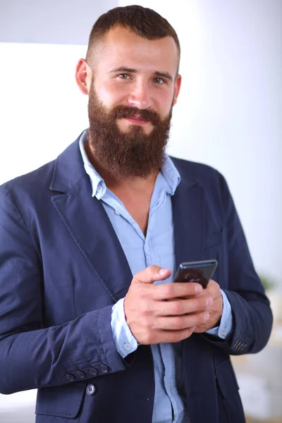 Hombre de negocios guapo en traje y anteojos hablando por teléfono en la oficina —  Fotos de Stock