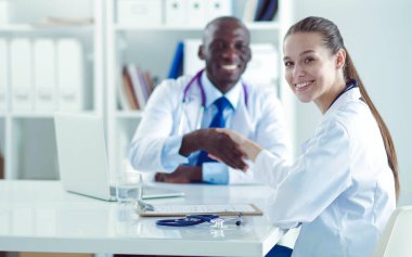 Ofiste tokalaşırken gülümseyen iki genç tıp adamı. Doktorlar. Takım çalışması.