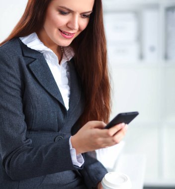 uśmiechnięta kobieta filiżanki jednorazowe i smartphone 