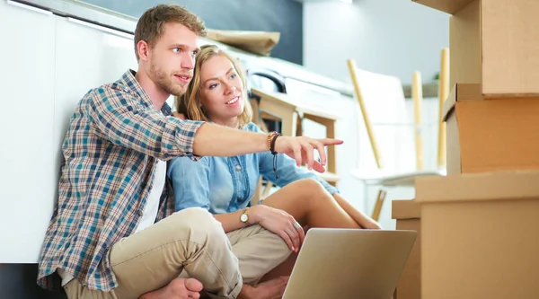 Genç bir çift yeni ev içinde hareket. Oturma ve açma sonra rahatlatıcı. Bir şey üstünde laptop arıyorum. Genç Çift