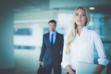 Kredi kartı tutan ve dizüstü bilgisayar kullanan genç bir kadın. Çevrimiçi alışveriş kavramı