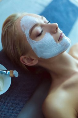Yüz maskesi. Güzel genç kız Spa, makyajcısı kadın yüz maskesi uygulama.
