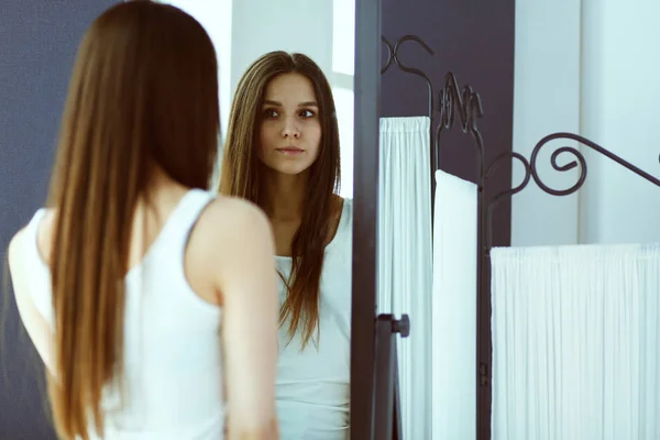 Jonge vrouw zichzelf reflectie in spiegel thuis kijken. — Stockfoto