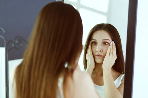 Jonge vrouw zichzelf reflectie in spiegel thuis kijken. — Stockfoto
