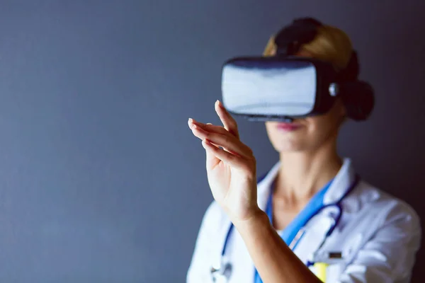 Female doctor wearing virtual reality glasses isolated on white background.