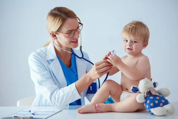 Ženský doktor poslouchá dítě se stetoskopem na klinice — Stock fotografie