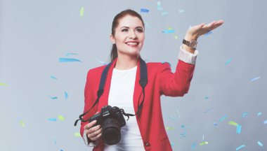 Kamera ile konfeti kutlama partisinde güzel mutlu kadınla. Doğum günü veya yeni yıl arifesi kavramı kutlama