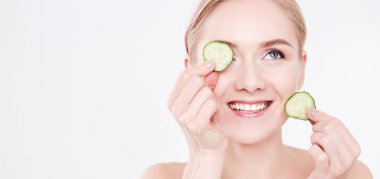 Beyaz zemin üzerine salatalık dilimleri ile genç güzel kadın