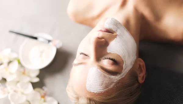 Ansiktsmask. Vacker ung flicka på spa, cosmetician kvinna tillämpa ansiktsmask — Stockfoto