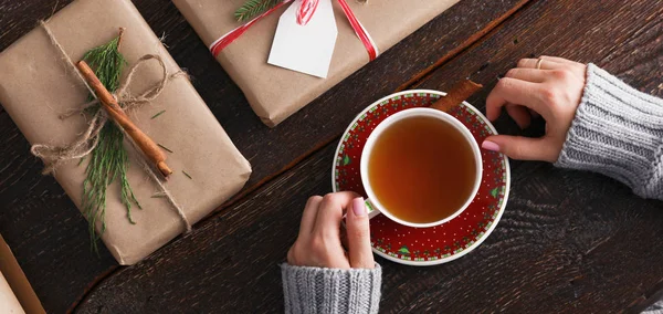 Femme assise sur le bureau avec boîte cadeau de Noël. Mains de femme — Photo