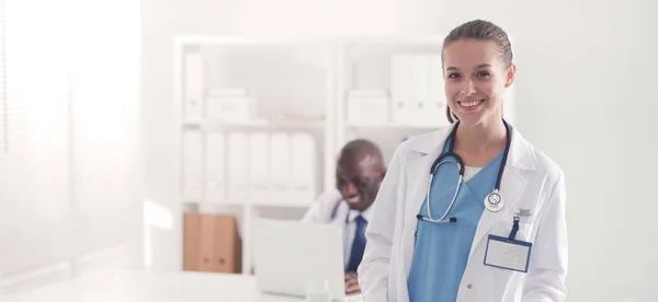 Dwoje uśmiechniętych młodych medyków ściskających dłonie w biurze. Lekarze. Praca zespołowa — Zdjęcie stockowe