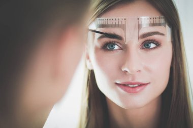 Kaşlar için kalıcı makyaj. Güzellik salonunda kalın kaşlı güzel bir kadın..