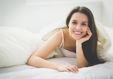 Güzel bir kadın yatağında uzanıyor..