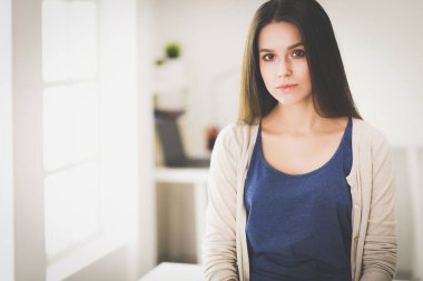 Genç kadın kendini evde aynada yansıma arıyor.