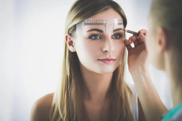 Maquillaje permanente para cejas. Primer plano de mujer hermosa con cejas gruesas en salón de belleza. — Foto de Stock