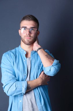 Mutlu bir casual adam ayakta karanlık bir arka plan üzerinde izole portresi. Yakışıklı erkek poz.