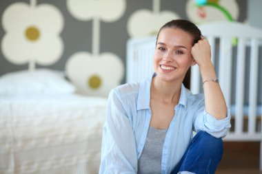 Çocuk karyolası yakın katta oturan bir genç bayan. Genç anne.