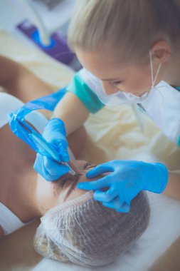 Kaşlar için kalıcı makyaj. Güzellik salonunda kalın kaşlı güzel bir kadın..