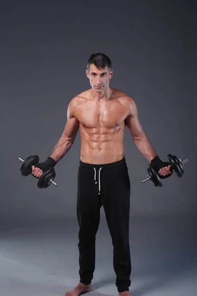 Yakışıklı kaslı adam dumbell ile çalışma dışarı. Kişisel fitness eğitmeni. Kişisel eğitim. — Stok fotoğraf